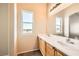 Bright bathroom with double sinks, large mirror, and window bringing in natural light at 8842 Duncan Barrel Ave # 103, Las Vegas, NV 89178