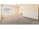 Large bedroom with neutral walls, plush carpet, window with blinds, and an arched doorway at 8842 Duncan Barrel Ave # 103, Las Vegas, NV 89178