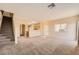 Open-concept living room and staircase with neutral carpet and paint at 8842 Duncan Barrel Ave # 103, Las Vegas, NV 89178