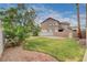 Well-maintained backyard with a lush lawn, stone patio, and mature trees provides privacy and natural beauty at 108 Parker Ranch Dr, Henderson, NV 89012