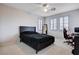 Modern bedroom features a black bed frame, three shuttered windows, and a dedicated gaming space at 108 Parker Ranch Dr, Henderson, NV 89012