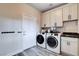 Functional laundry room with modern washer and dryer, cabinets, and a sink at 108 Parker Ranch Dr, Henderson, NV 89012