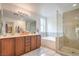 Elegant bathroom with double vanity, soaking tub, a glass-enclosed shower for a luxurious experience at 161 Swale Ln, Las Vegas, NV 89144