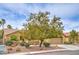 Street view of single story stucco home with mature landscaping, desert rock accents, and tile roof at 161 Swale Ln, Las Vegas, NV 89144