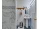 Bathroom featuring white tile walls, a modern pedestal sink, and fixtures at 1949 King Hill St, Las Vegas, NV 89106