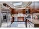 Well-lit kitchen featuring stainless steel appliances, dark wood cabinets and a light-colored tile floor at 1949 King Hill St, Las Vegas, NV 89106