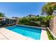 Backyard pool with blue tile accents and lush landscaping perfect for relaxing and entertaining under the sun at 1949 King Hill St, Las Vegas, NV 89106