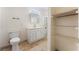 Bright bathroom featuring white vanity, toilet, and open shelving next to shower at 2141 Hussium Hills St # 108, Las Vegas, NV 89108