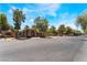 Exterior view of a clubhouse with landscaped grounds and ample parking under a bright blue sky at 2141 Hussium Hills St # 108, Las Vegas, NV 89108