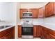 Well-lit kitchen with stainless steel oven, microwave, and cherry wood cabinets at 2141 Hussium Hills St # 108, Las Vegas, NV 89108
