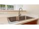 Close-up of a stainless steel kitchen sink with modern faucet and white countertops at 2141 Hussium Hills St # 108, Las Vegas, NV 89108