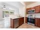 Modern kitchen with stainless appliances, sleek counter, and cherry cabinets overlooking the living room at 2141 Hussium Hills St # 108, Las Vegas, NV 89108