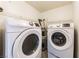A laundry room featuring a washer and dryer with white wire shelving above at 2141 Hussium Hills St # 108, Las Vegas, NV 89108