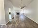 Spacious living room featuring sleek wood-look floors, a brick fireplace, a ceiling fan, and natural light at 3619 Edinburgh Dr, Las Vegas, NV 89103