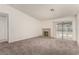 Bright living room featuring neutral carpet, a fireplace, and sliding glass door access to backyard at 4416 Rip Van Winkle Ln, Las Vegas, NV 89102
