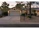 Inviting single-story home with a two-car garage, decorative details, and well-maintained front yard at 4908 Winterset Dr, Las Vegas, NV 89130