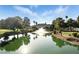 Close-up view of the pond featuring a fountain, mature trees, and community landscaping at 4908 Winterset Dr, Las Vegas, NV 89130