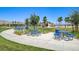 Bright, inviting picnic area with blue tables surrounded by walking paths and lush landscaping at 5617 Craftsman Ave, Las Vegas, NV 89122