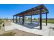 Open air picnic shelter featuring grill and blue picnic tables offers shade and gathering space at 5617 Craftsman Ave, Las Vegas, NV 89122