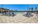Community swimming pool featuring lounge chairs, palm trees, and mountain views at 5617 Craftsman Ave, Las Vegas, NV 89122