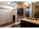 Well-lit bathroom featuring a glass shower, dark vanity and cabinet storage at 6 Yorkridge Ct, Henderson, NV 89052