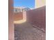 Narrow side yard with rock landscaping and brick wall surround at 8089 Windmill Villa St, Las Vegas, NV 89139