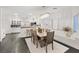 Bright dining room with wood table, elegant light fixture, and an adjacent modern white kitchen at 8325 Winterchase Pl, Las Vegas, NV 89143