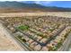 Expansive aerial view of a well-planned community with houses featuring desert landscaping, pools and solar panels at 8929 Monte Oro Dr, Las Vegas, NV 89131