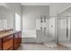 This bathroom offers a tub, glass enclosed shower, dark wood vanity and tile flooring at 8929 Monte Oro Dr, Las Vegas, NV 89131