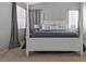 This bedroom features neutral colors, carpet, large windows and a four-poster bed with stylish gray accents at 8929 Monte Oro Dr, Las Vegas, NV 89131