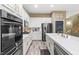 Modern kitchen with white cabinets, stainless steel appliances, and a center island with a marble countertop at 8929 Monte Oro Dr, Las Vegas, NV 89131