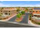 Gated community entrance showing desert landscaping, brick walls, and community pool in background at 8929 Monte Oro Dr, Las Vegas, NV 89131