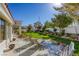 Well-manicured backyard featuring a lush lawn, patio area, seating, and mature trees at 9201 Yucca Blossom Dr, Las Vegas, NV 89134