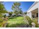 Well-maintained backyard with lush green lawn, mature trees, and privacy landscaping at 9201 Yucca Blossom Dr, Las Vegas, NV 89134