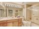 Clean bathroom with a long vanity, sink, tub, shower, and large mirror, providing a refreshing and well-lit space at 9201 Yucca Blossom Dr, Las Vegas, NV 89134