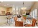 Eat-in kitchen dining area features a modern light fixture, bar seating, and overlooks the bright living area at 9201 Yucca Blossom Dr, Las Vegas, NV 89134