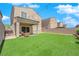 This backyard features artificial turf, a covered patio with seating, and a playhouse, all enclosed by a brick wall at 9947 Tucket Point Ct, Las Vegas, NV 89178