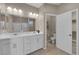 Modern bathroom featuring dual sinks, quartz countertop, tile floors, and a glass shower enclosure at 9947 Tucket Point Ct, Las Vegas, NV 89178