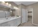 Modern bathroom featuring dual sinks, quartz countertop, tile floors, and a glass shower enclosure at 9947 Tucket Point Ct, Las Vegas, NV 89178