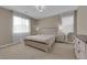 Cozy bedroom features neutral decor, carpeted floor, large window with sheer curtains, and modern light fixture at 9947 Tucket Point Ct, Las Vegas, NV 89178