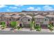 View of this two story home, with desert landscaping, brick driveway, and a two car garage at 9947 Tucket Point Ct, Las Vegas, NV 89178
