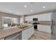 Modern kitchen island with stainless steel appliances and backyard view at 9947 Tucket Point Ct, Las Vegas, NV 89178