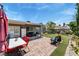 Spacious backyard featuring a covered patio, well-maintained lawn, lush greenery, and inviting seating creates a perfect outdoor at 2093 Seahurst Dr, Las Vegas, NV 89142