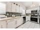 A modern kitchen featuring stainless steel appliances and sleek white cabinetry and backsplash at 2093 Seahurst Dr, Las Vegas, NV 89142