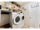 Laundry room with white washer and dryer, overhead shelves and tile flooring is practical and organized at 2093 Seahurst Dr, Las Vegas, NV 89142
