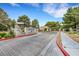 Community entrance with lush trees, brick walls, and paved driveway at 2627 S Durango Dr # 201, Las Vegas, NV 89117