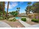 Community pool area with desert landscaping, tall palm trees, and pergola covered seating at 2627 S Durango Dr # 201, Las Vegas, NV 89117