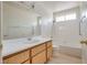 This bathroom features wood cabinets and tile in the bath and shower at 4630 Pratt Way, Las Vegas, NV 89147