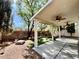 Backyard featuring a covered patio and spacious, landscaped yard with mature trees at 5517 Overlook Valley St, North Las Vegas, NV 89081