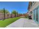 Backyard with artificial grass, patio, string lights, and secure fencing at 5716 Breckenridge St, North Las Vegas, NV 89081